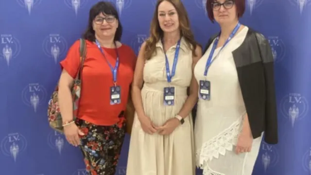 A kongresszusi fotóháttér előtt áll 3 főnővér.